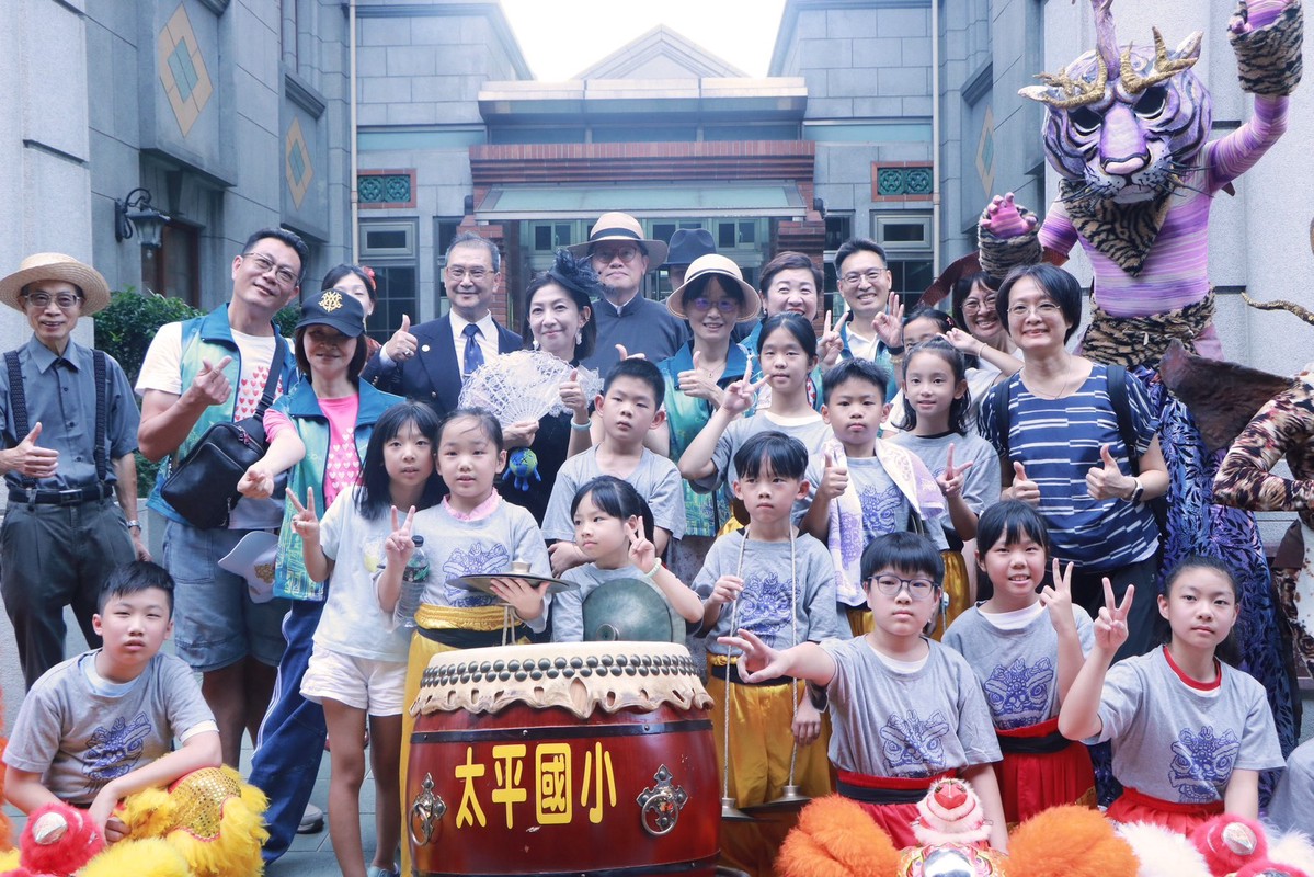 「時空藝陣1920變裝遊行」登場,與會來賓與太平國小學童及變裝表演者合影,共同感受大稻埕的文化活力。